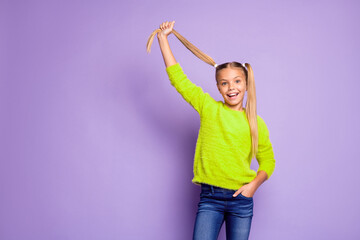 Wall Mural - Portrait of cheerful kid enjoy fun weekends hold pigtails wear casual style clothing isolated over purple color background