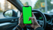 © Pixelbus - Hands holding a smartphone with a green mock-up screen inside a car, with a sharp foreground and blurred background, symbolizing technology and mobility.
