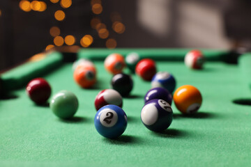 Wall Mural - Many colorful billiard balls on green table indoors, closeup