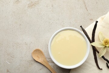 Wall Mural - Tasty condensed milk, vanilla pods, flower and spoon on light grey table, flat lay. Space for text