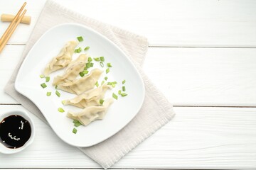 Sticker - Tasty boiled gyoza (dumplings) served on white wooden table, flat lay. Space for text