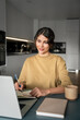 © Stock 4 You - Vertical shot latin businesswoman woman entrepreneur using computer for online remote business studying writing notes. Serious concentrated young hispanic female student working on laptop pc at home