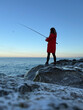 © Sunny studio - Young happy woman is fishing at sea during spring vacation