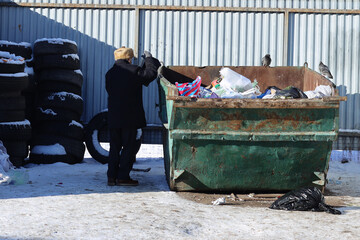 Poster - A person standing beside a trash dumpster filled with waste, suitable for environmental or community awareness themes.