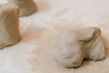 Poster - Hands of a female potter making ceramic clay product on the table in the pottery workshop. Potter is sculpting wet clay for ceramics products.