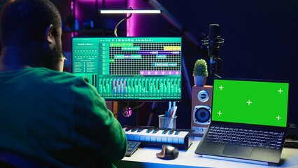 Leinwandbilder - Music producer mixing and mastering songs on digital post production pc interface, green screen display. Artist adding sound effects and adjusting volume levels to produce new music. Camera B.