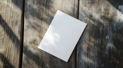 Poster - Blank White Paper on Wooden Table Surrounded by Natural Light and Shadows