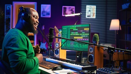 Fototapete - Confident songwriter performing a tune on microphone in home studio, recording his song and editing in post production. Performer artist singing aloud and using stereo equipment. Camera B.