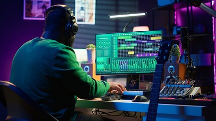 Poster - Producer composing new music on acoustic instrument in home studio, using microphone to sing chords. Musician songwriter works with mixing console and software, guitarist producing tunes. Camera A.