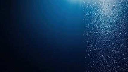 Poster - A deep blue underwater scene with shimmering particles illuminated by light, creating a tranquil and serene atmosphere.