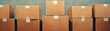 © Nopadon - A row of stacked cardboard boxes, neatly organized, set against a simple background, emphasizing storage and logistics.