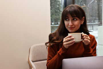 Wall Mural - Beautiful woman having coffee break in cafe. Space for text