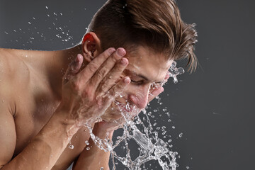 Wall Mural - Man washing his face on grey background