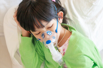 Sick little asian girl inhalation with nebulizer for respiratory treatment