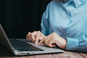 Poster - Close-Up of Hands Typing on Laptop Keyboard in Dim Light Setting, Business concept