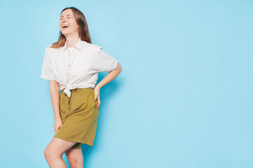 Sticker - Young beautiful smiling brunette female in trendy summer  clothes. Carefree woman posing near blue wall in studio. Positive model. Cheerful and happy