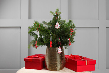 Wall Mural - Beautiful decorated fir tree branches and Christmas gifts on pouf indoors