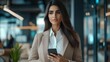 © Pichapob - Stylish Middle Eastern Businesswoman in Tailored Suit with Smartphone
