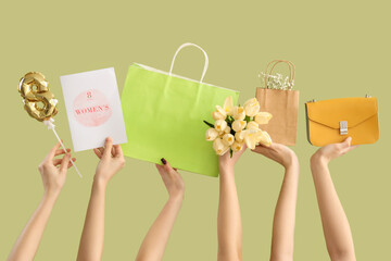 Wall Mural - Female hands with bouquet of tulips, shopping bags and festive postcard on green background. International Women's Day