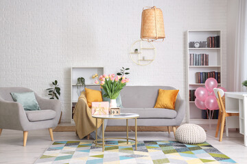 Wall Mural - Interior of living room with sofa and tulips in vase for International Women's Day