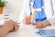 © Pixel-Shot - Male doctor explaining spinal anatomy with vertebral column model to patient in clinic, closeup
