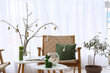© Pixel-Shot - Vase with tree branches, Easter eggs, candles and magazines on table in room