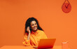 © Jacob Lund - Happy female call center employee laughing in a vibrant orange monochromatic workspace
