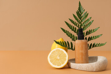 Canvas Print - Composition with bottle of cosmetic product, fern twig, stone stand and lemons on brown background