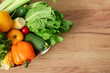 © Pixel-Shot - Wicker basket with different fresh vegetables on wooden kitchen counter, top view