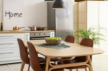 Wall Mural - Wicker bowl with apples on dining table in kitchen