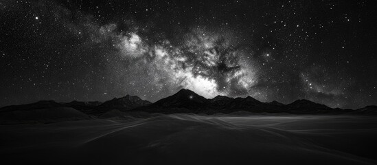 Wall Mural - Majestic black and white landscape with diverse textures, mountain silhouette against a starry sky, showcasing deep contrasts and celestial beauty.