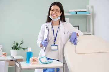 Wall Mural - Young female dentist with clipboard near couch in clinic