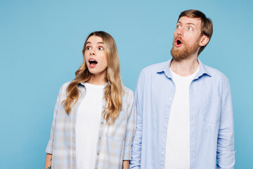 Canvas Print - Young shocked surprised couple two friends family man woman wearing shirt casual clothes together look aside on area isolated on pastel plain light blue background studio portrait. Lifestyle concept.