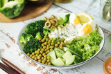 A bowl with a salad made of green vegetables	