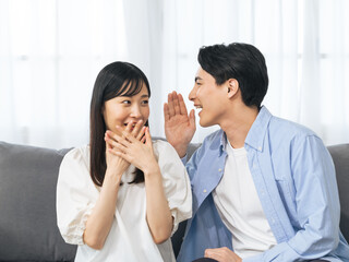 Aufkleber - 夫婦、カップル、内緒、告白、秘密、驚く、喜ぶ、嬉しい、教える、報告、びっくり、驚き、サプライズ、プレゼント、ニュース、知らせる、ハッピー、ラブラブ、新婚、結婚、プロポーズ、ヒソヒソ、話、話す、会話、コミュニケーション、若い、日本人、男性、女性、恋人、口説く、コピースペース、室内、暮らし、ライフスタイル、住宅、リビングルーム、お知らせ、意外、家族、仲良し、リラックス、祝福、お祝い、感謝、打ち明ける、