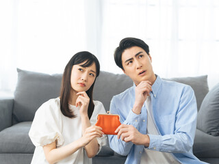 Leinwandbilder - お金、貯金、コスト、ローン、財布、夫婦、カップル、家計、不安、疑問、考える、心配、不満、出費、収入、経費、費用、マイホーム、家賃、副業、検討、悩む、悩み、困る、問題、トラブル、銀行、口座、確定申告、投資、資産運用、NISA、iDeCo、保険、経済、金融、財産、不足、失敗、迷う、給料、カジュアル、室内、部屋、日本人、男性、女性、結婚、引越し、人物