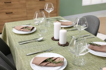 Wall Mural - Stylish table setting with olive tablecloth, glasses and candles indoors