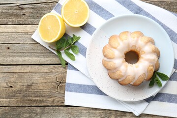 Wall Mural - Tasty lemon cake with glaze, fresh fruits and mint on wooden table, flat lay. Space for text