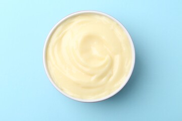 Wall Mural - Tasty vanilla pudding on light blue background, top view
