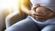 © Jorda - Stomach pain felt by a young woman sitting on a chair, holding her stomach. Featuring discomfort and recovery
