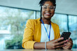 © Jacob Lund - Confident businesswoman smiling while texting in modern office