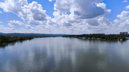 blue sky with white clouds reflected in y=the danube river in novi sad