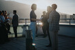 © qunica.com - Diverse colleagues gather on a high-rise balcony to brainstorm creative ideas under the setting sun. The scene captures the spirit of teamwork and innovation in a multicultural business environment.