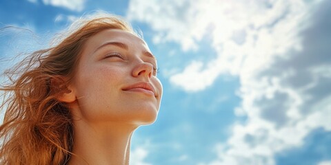 Aufkleber - A woman with her eyes closed gazing up at the clear blue sky, possibly lost in thought or prayer