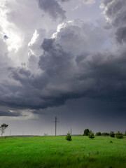 Wall Mural - Stormy sky with a tall pole in the middle of a field