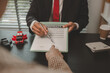 © kamiphotos - a car salesperson is explaining the details of a car purchase contract to the buyer before signing the sales contract, showroom, dealer, car contract, sining a car purchase contract