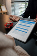 © kamiphotos - a lawyer is explaining the details of a car insurance policy to the car owner before she signs it, a lawyer explains to his client what will happen if she doesn't get car insurance