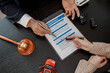 © kamiphotos - a lawyer is explaining the details of a car insurance policy to the car owner before she signs it, a lawyer explains to his client what will happen if she doesn't get car insurance