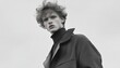 © Yopi - Portrait of a Young Man with Curly Hair in a Dark Coat