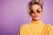 © Lubos Chlubny - Fashion model wearing yellow sunglasses and sweater posing on purple background